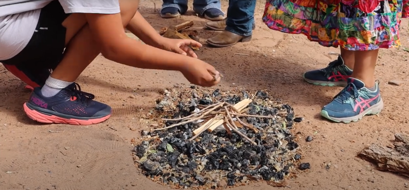 A group of students gathered around a campfire, enjoying their time together outdoors.